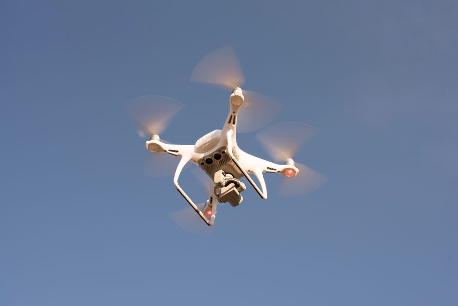 A surveillance drone inspecting power lines in rugged terrain, showcasing advanced technology for utility inspections.